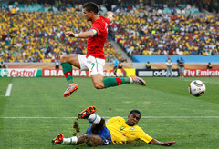 A portugál Cristiano Ronaldo ugorja át a brazil Juan lábát